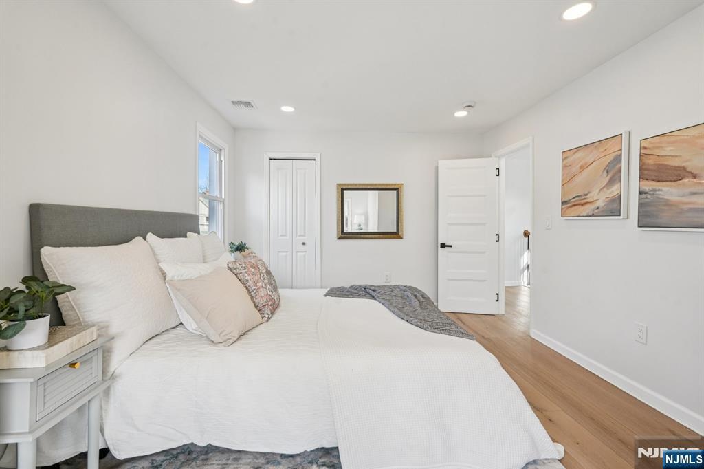 51 Highland Place Ridgefield Park, NJ 07660 - Photo 23 of 35 a bedroom with a large bed and a chandelier