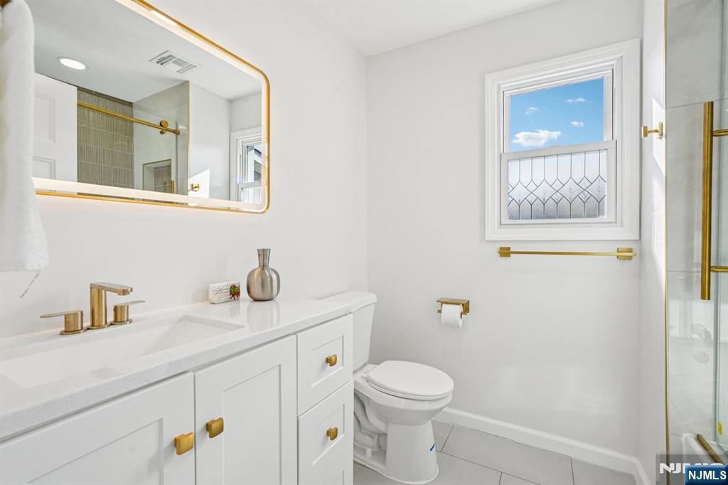 51 Highland Place Ridgefield Park, NJ 07660 - Photo 24 of 35 a bathroom with a toilet a sink and mirror