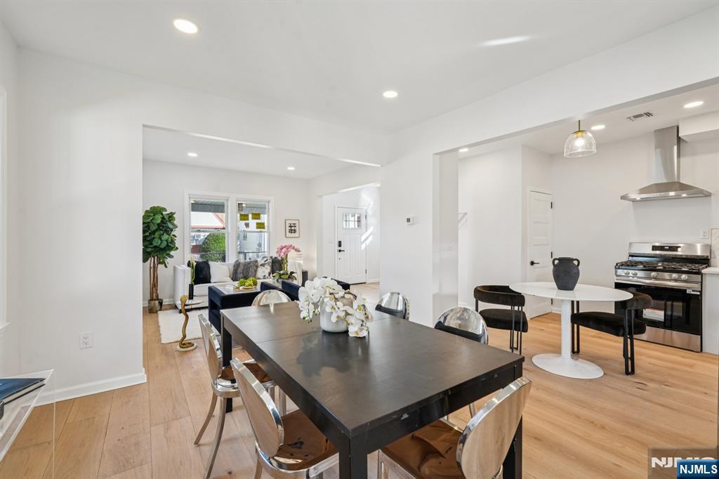 51 Highland Place Ridgefield Park, NJ 07660 - Photo 10 of 35 a view of a dining room and livingroom with furniture wooden floor a rug a potted plant and a chandelier