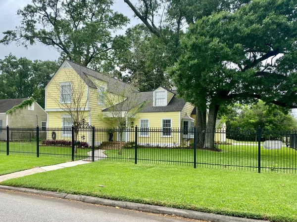 a front view of a house with a yard and trees