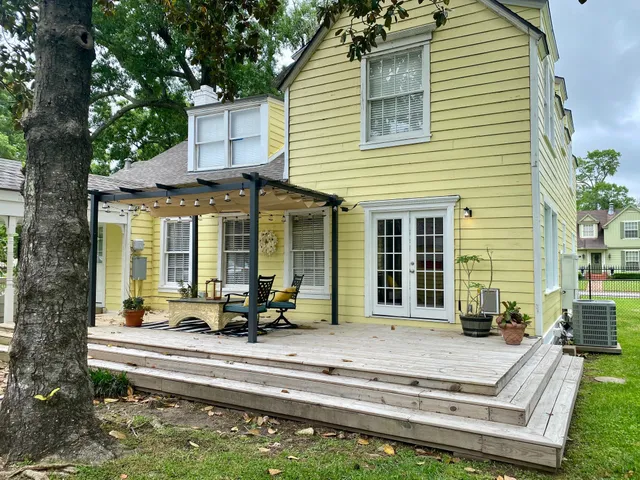 a front view of a house with a large windows and a table and chairs