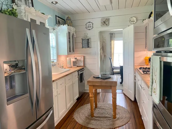 a kitchen with stainless steel appliances granite countertop a refrigerator a stove and a sink