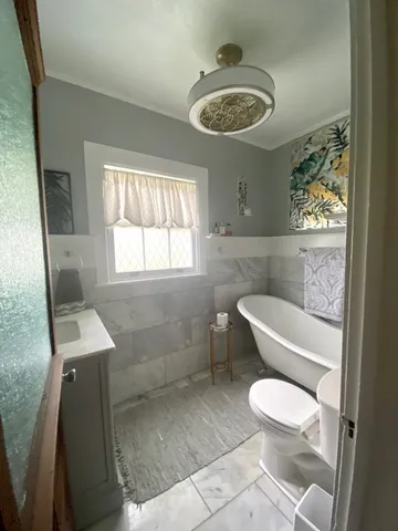 a bathroom with a toilet a sink and mirror