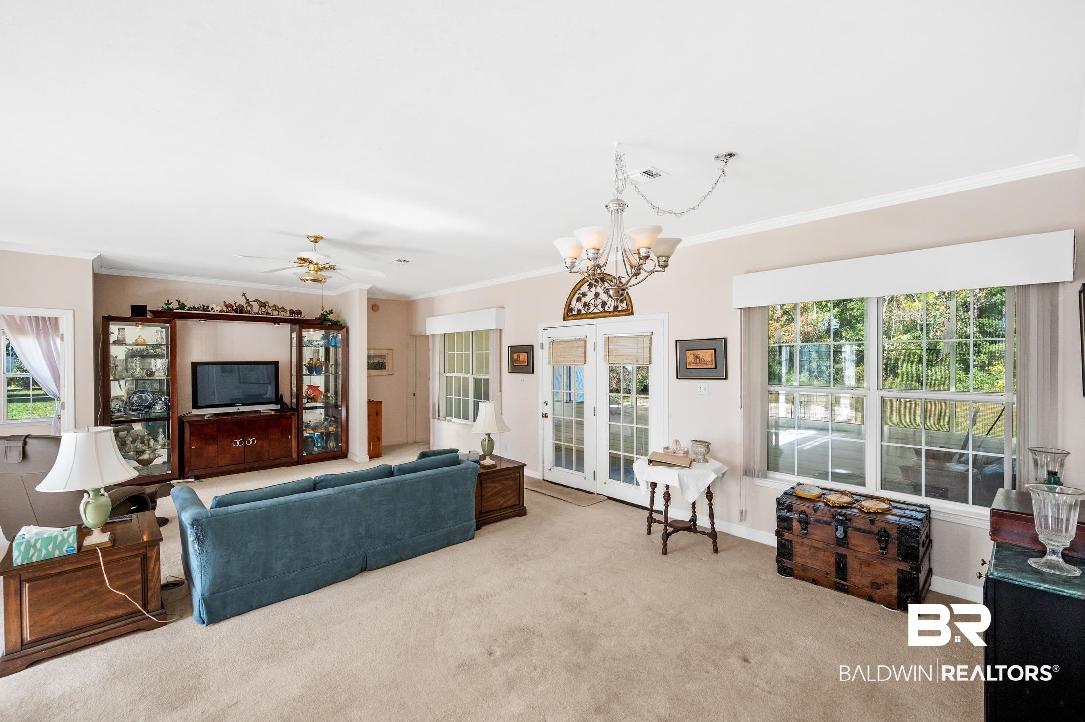 9260 Bay Point Drive Elberta, AL 36530 - Photo 9 of 34 Carpeted living room with ornamental molding and ceiling fan with notable chandelier