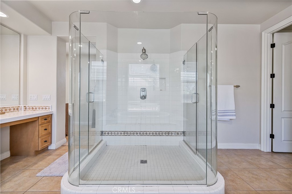 4959 Shady Trail Street Simi Valley, CA 93063 - Photo 21 of 40 a bathroom with a granite countertop shower a mirror and a sink