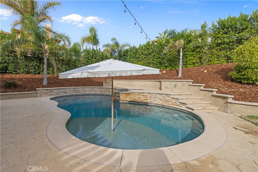 4959 Shady Trail Street Simi Valley, CA 93063 - Photo 33 of 40 a swimming pool with outdoor seating yard and trees in the background