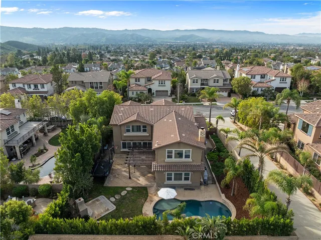 an aerial view of residential houses with outdoor space and trees