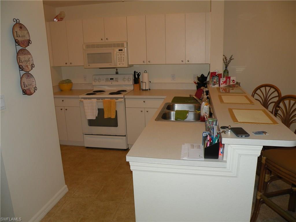 4440 Botanical Pl Circle, Unit 404 Naples, FL 34112 - Photo 4 of 11 a utility room with sink dryer and washer