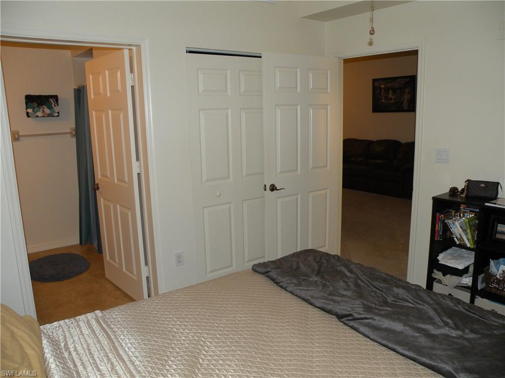 4440 Botanical Pl Circle, Unit 404 Naples, FL 34112 - Photo 5 of 11 a bedroom with a bed and a furniture