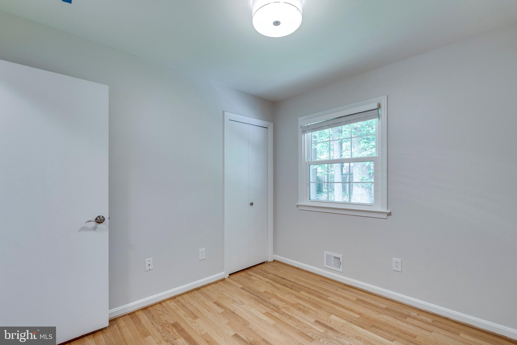 9808 Brixton Lane Bethesda, MD 20817 - Photo 14 of 24 a view of an empty room with wooden floor and a window