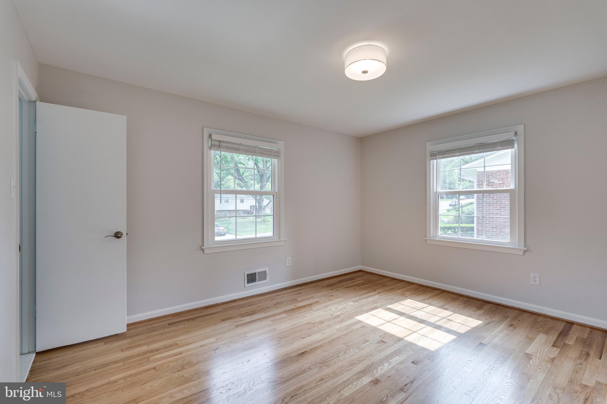 9808 Brixton Lane Bethesda, MD 20817 - Photo 15 of 24 a view of empty room with wooden floor and fan