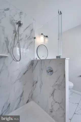 a bathroom with a granite countertop shower and a mirror