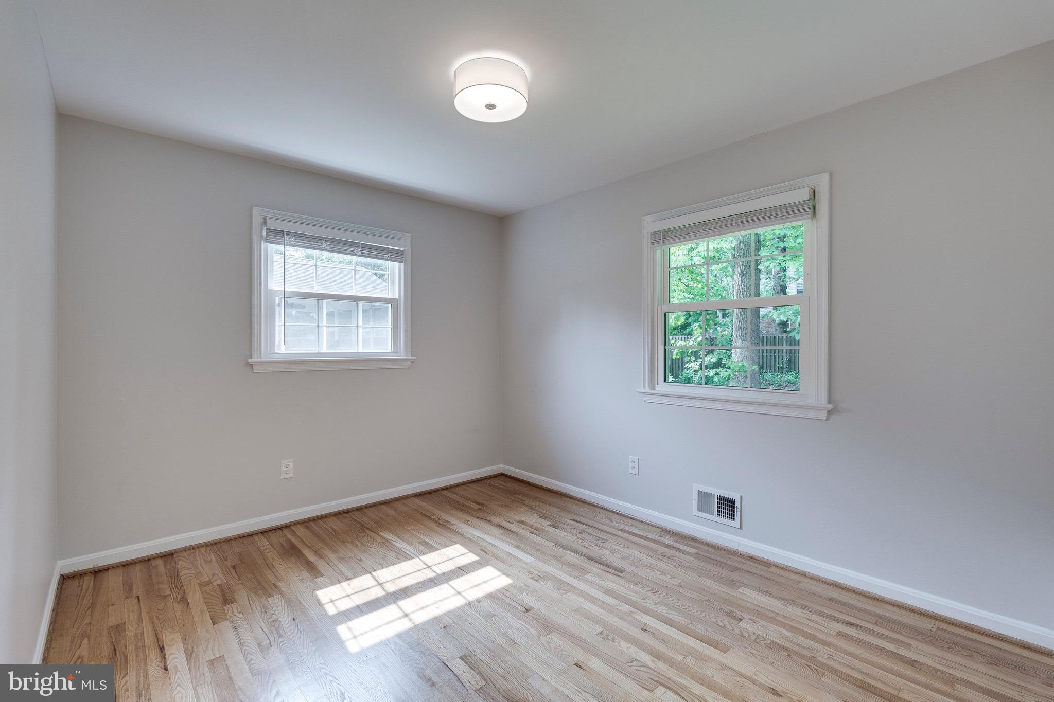 9808 Brixton Lane Bethesda, MD 20817 - Photo 19 of 24 an empty room with wooden floor and windows