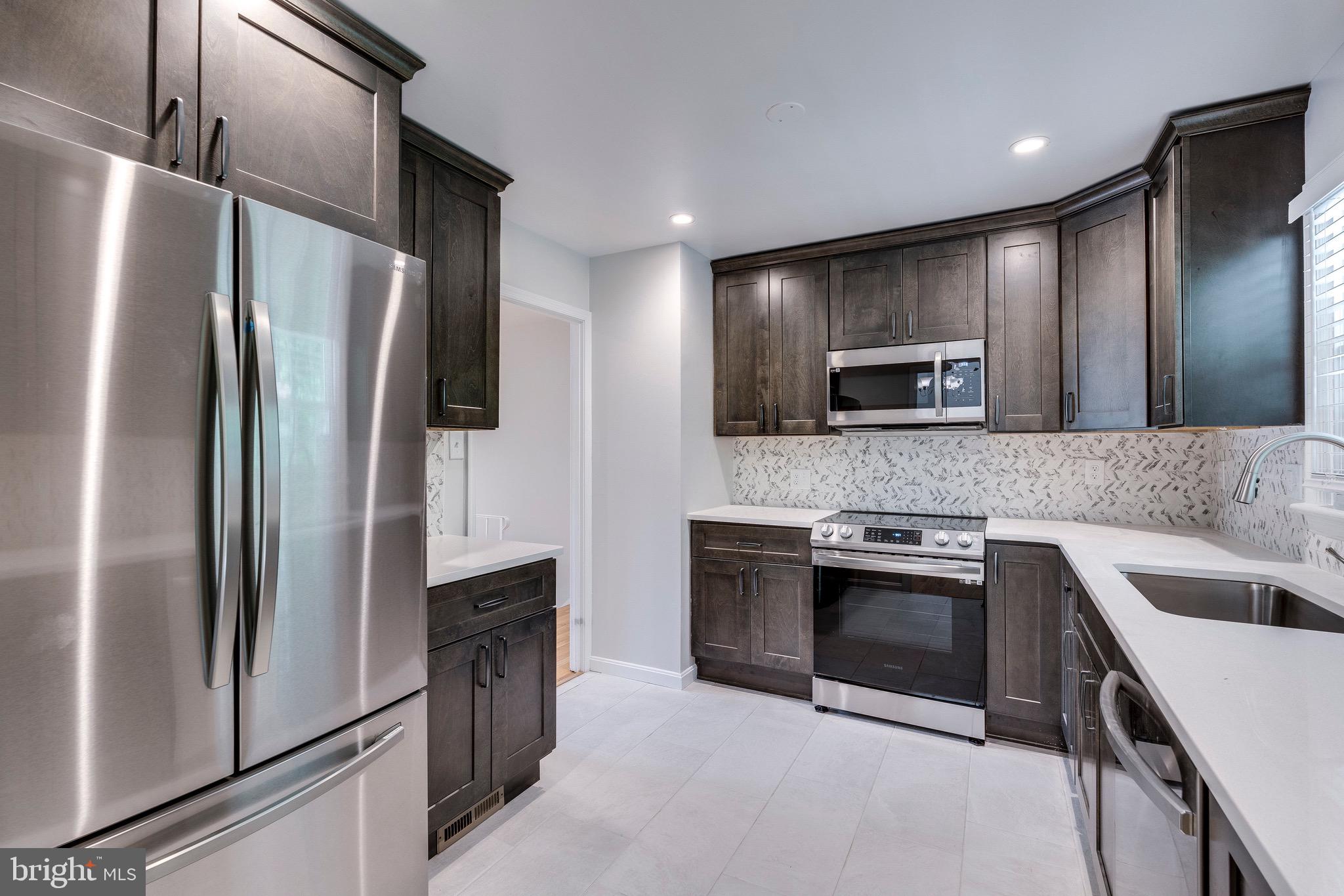 9808 Brixton Lane Bethesda, MD 20817 - Photo 9 of 24 a kitchen with stainless steel appliances granite countertop a refrigerator and a sink