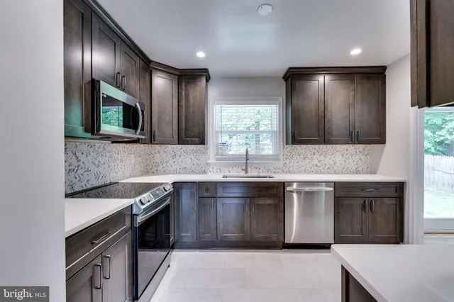 a kitchen with stainless steel appliances granite countertop a sink stove and microwave