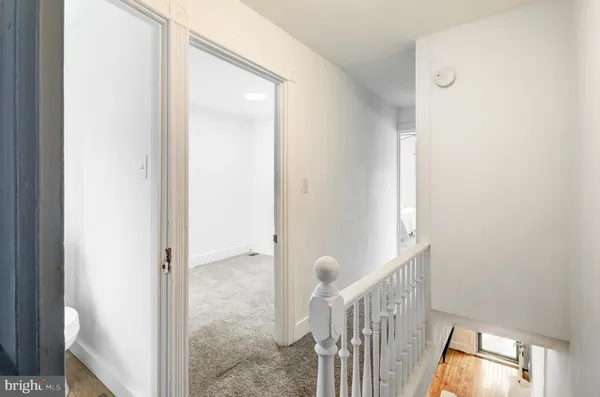 a view of a hallway with wooden floor and closet