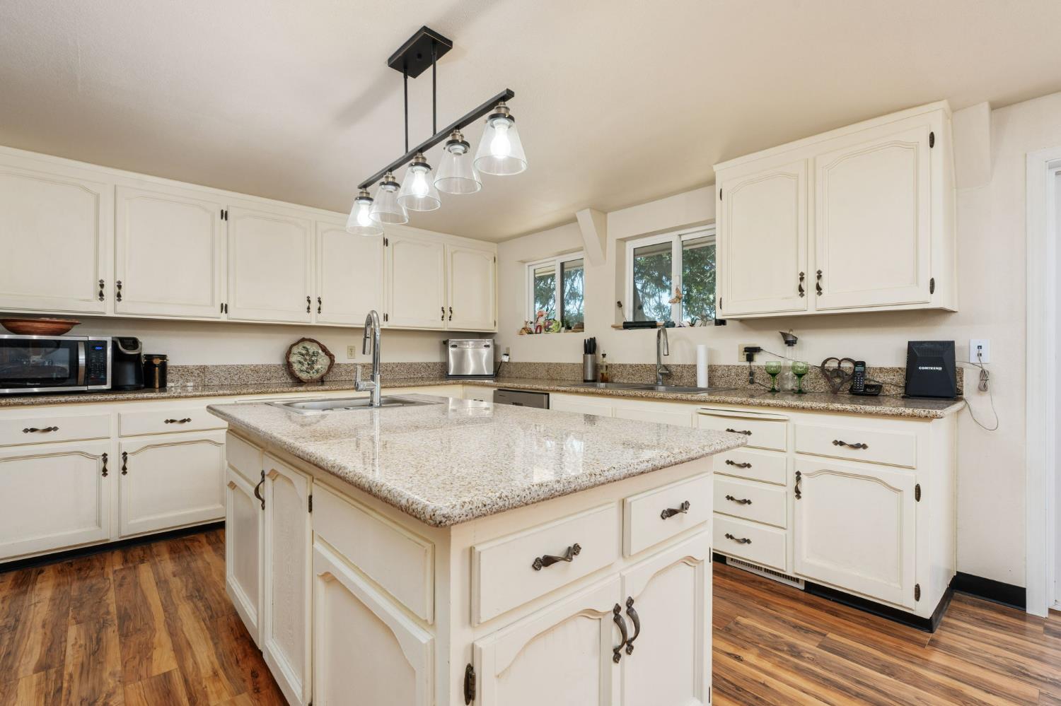 38303 Woodland Road Shaver Lake, CA 93664 - Photo 9 of 28 a kitchen with stainless steel appliances granite countertop a sink dishwasher and white cabinets with wooden floor