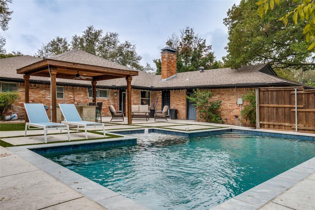 a view of a swimming pool with outdoor seating and plants