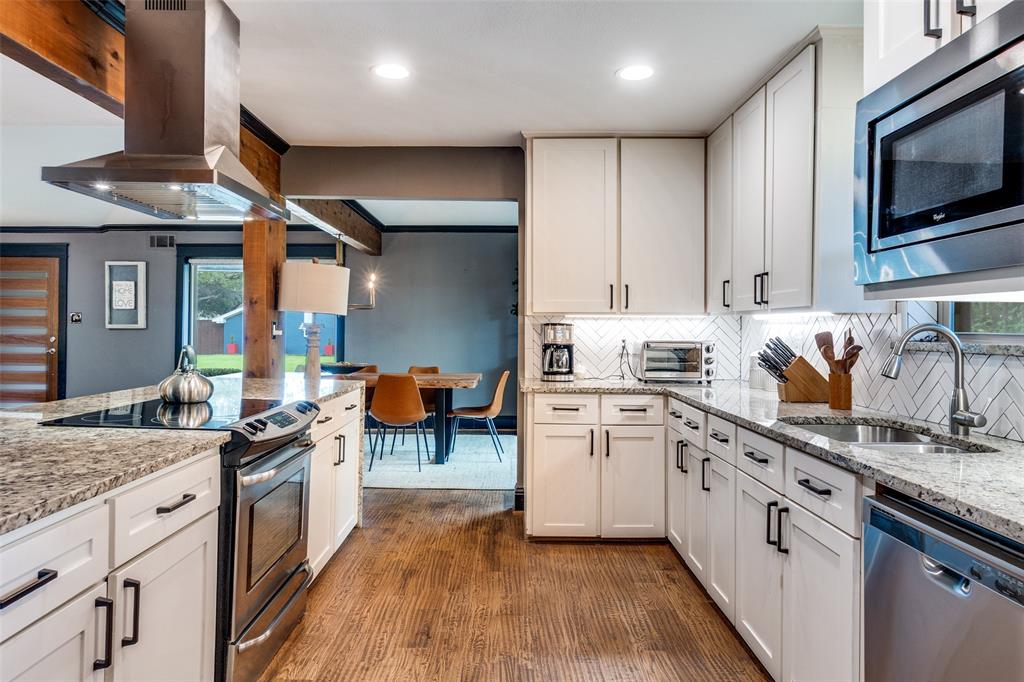 10355 Carry Back Circle Dallas, TX 75229 - Photo 13 of 35 a kitchen with stainless steel appliances granite countertop a stove top oven a sink dishwasher and white cabinets with wooden floor