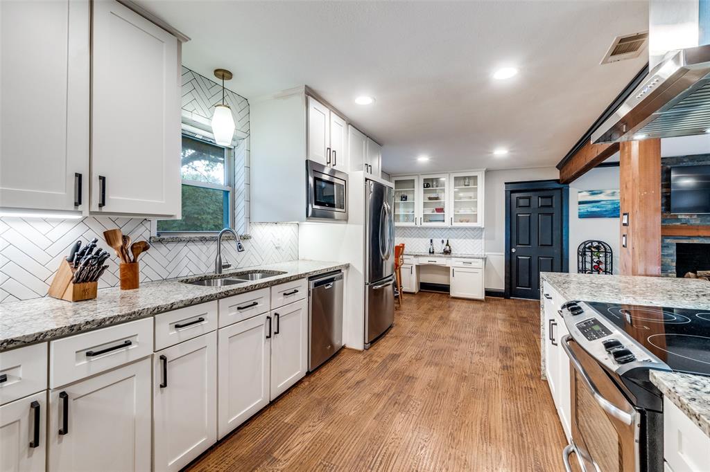 10355 Carry Back Circle Dallas, TX 75229 - Photo 14 of 35 a large kitchen with stainless steel appliances granite countertop a lot of counter space and wooden floors