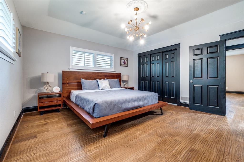 10355 Carry Back Circle Dallas, TX 75229 - Photo 23 of 37 a bedroom with a large bed chandelier and windows