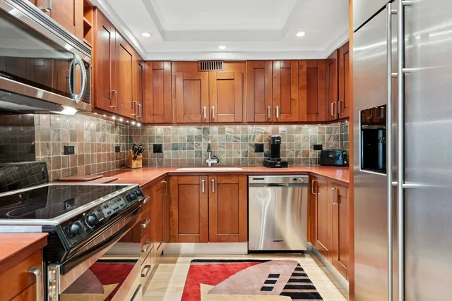 a kitchen with stainless steel appliances granite countertop a refrigerator and a stove