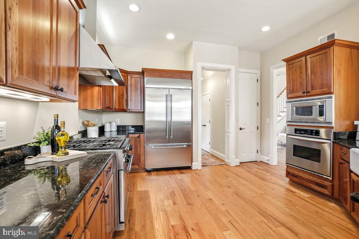 217 Talahi Road Southeast Vienna, VA 22180 - Photo 16 of 63 a kitchen with stainless steel appliances granite countertop a refrigerator a stove and a sink with wooden floor