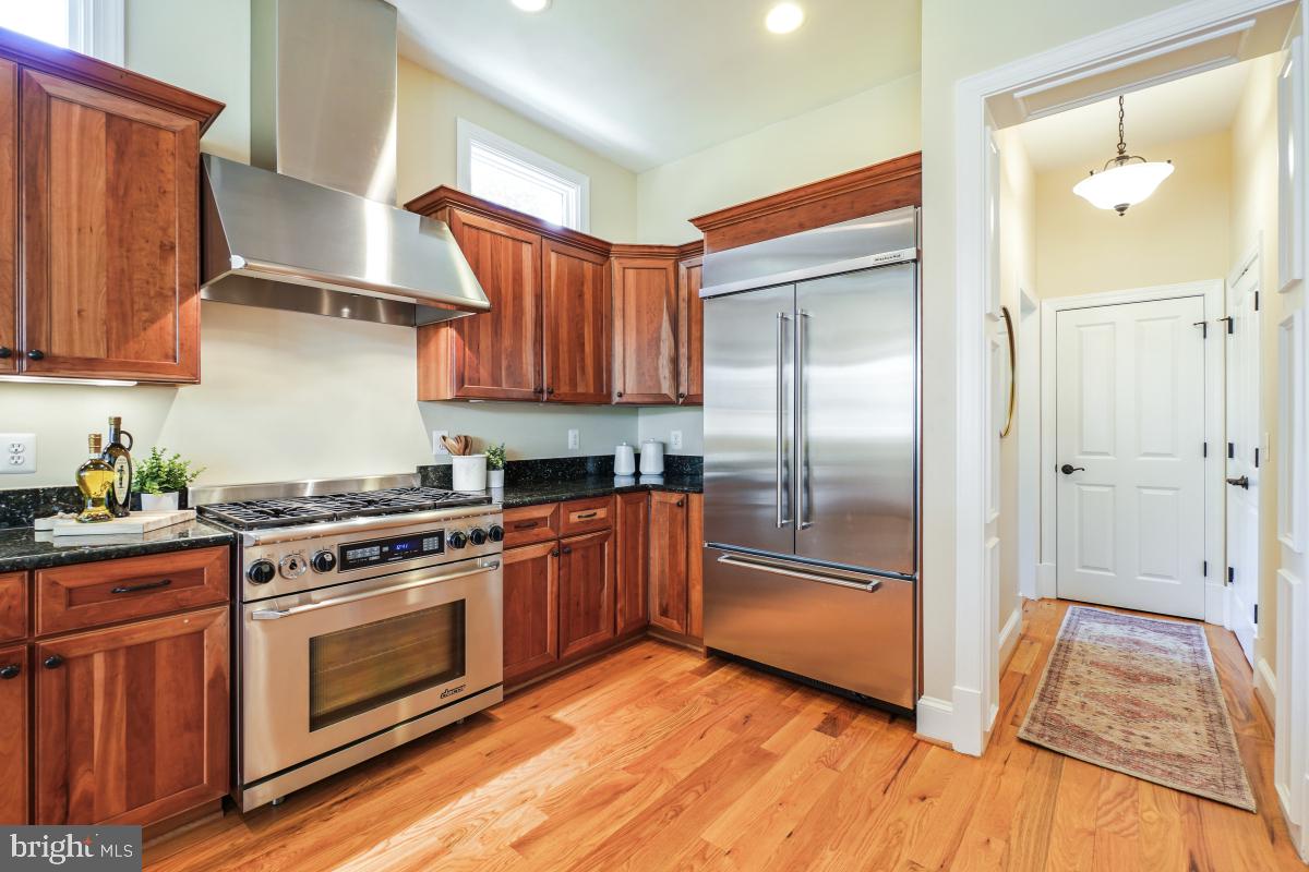 217 Talahi Road Southeast Vienna, VA 22180 - Photo 19 of 63 a kitchen with stainless steel appliances granite countertop a refrigerator a sink and wooden floors