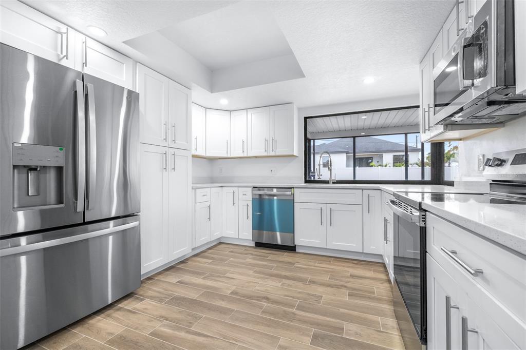 6312 Fairway Boulevard Apollo Beach, FL 33572 - Photo 13 of 58 a kitchen with a refrigerator a sink and dishwasher with wooden floor
