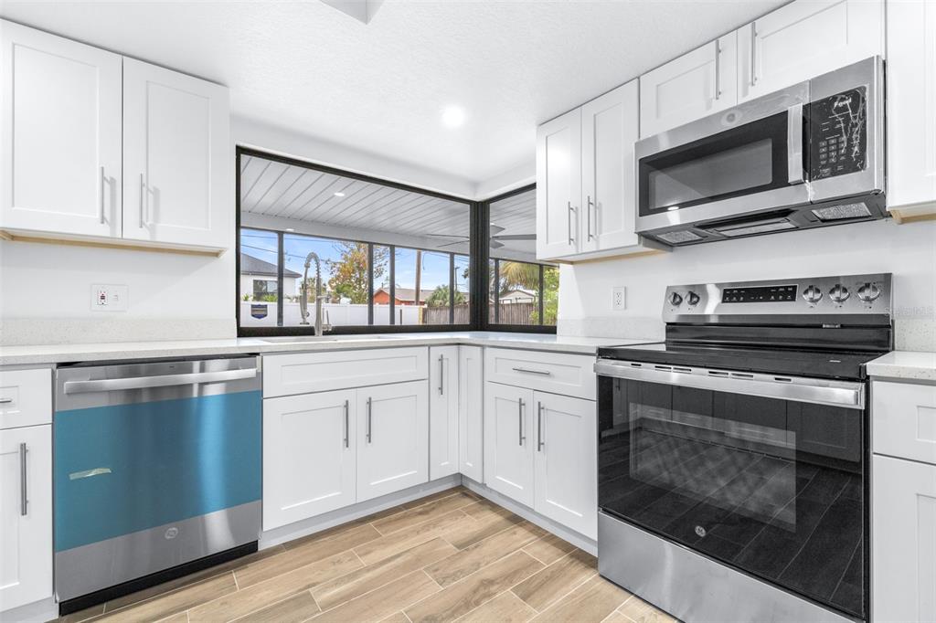 6312 Fairway Boulevard Apollo Beach, FL 33572 - Photo 14 of 58 a kitchen with stainless steel appliances granite countertop a stove microwave and sink