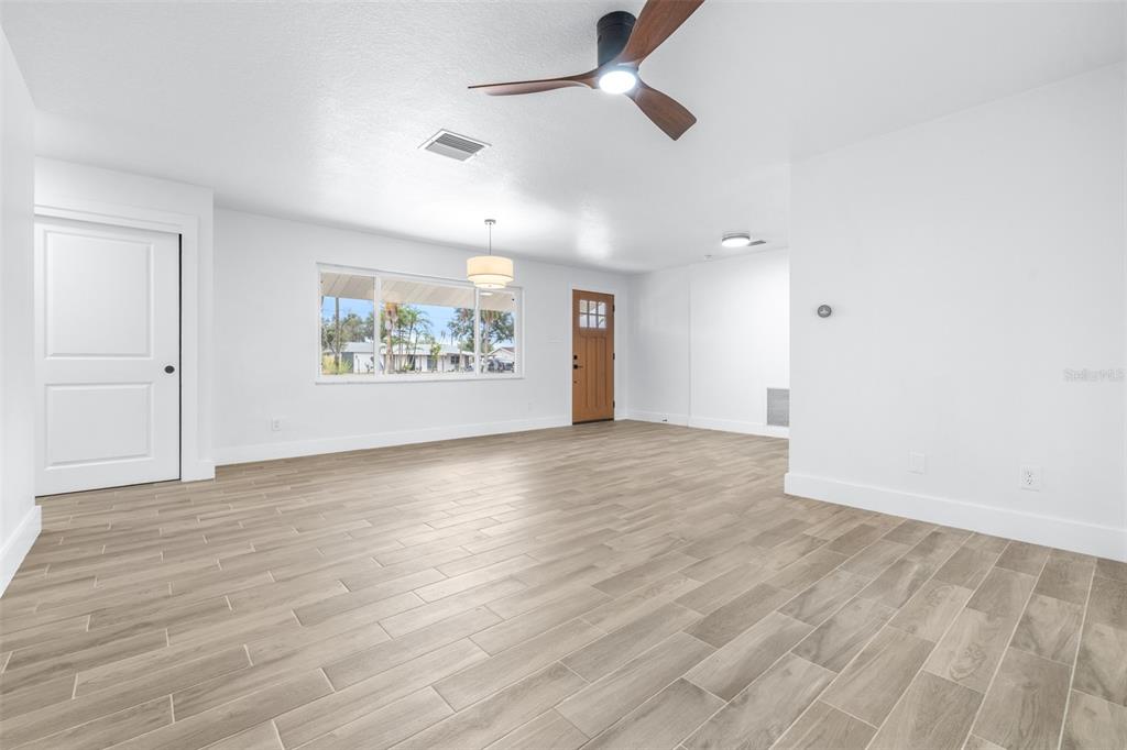6312 Fairway Boulevard Apollo Beach, FL 33572 - Photo 10 of 58 an empty room with wooden floor ceiling fan and windows