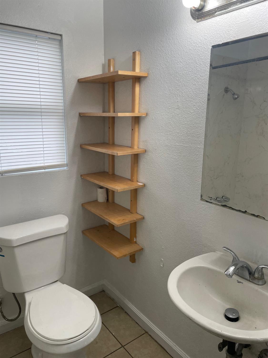 421 East Elm Street Lodi, CA 95240 - Photo 14 of 17 a bathroom with a sink a toilet and a window