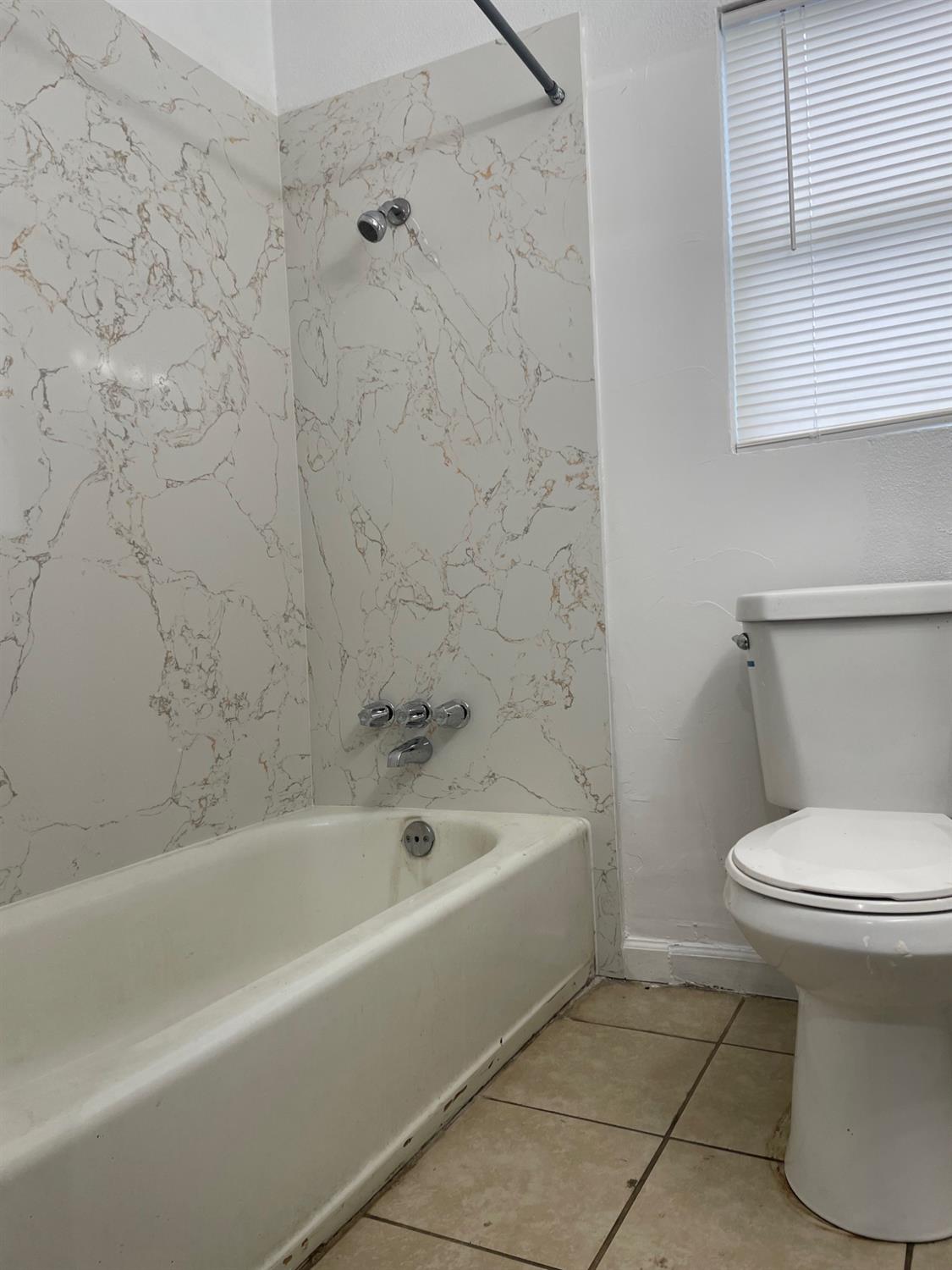 421 East Elm Street Lodi, CA 95240 - Photo 15 of 17 a white bath tub sitting next to a white toilet