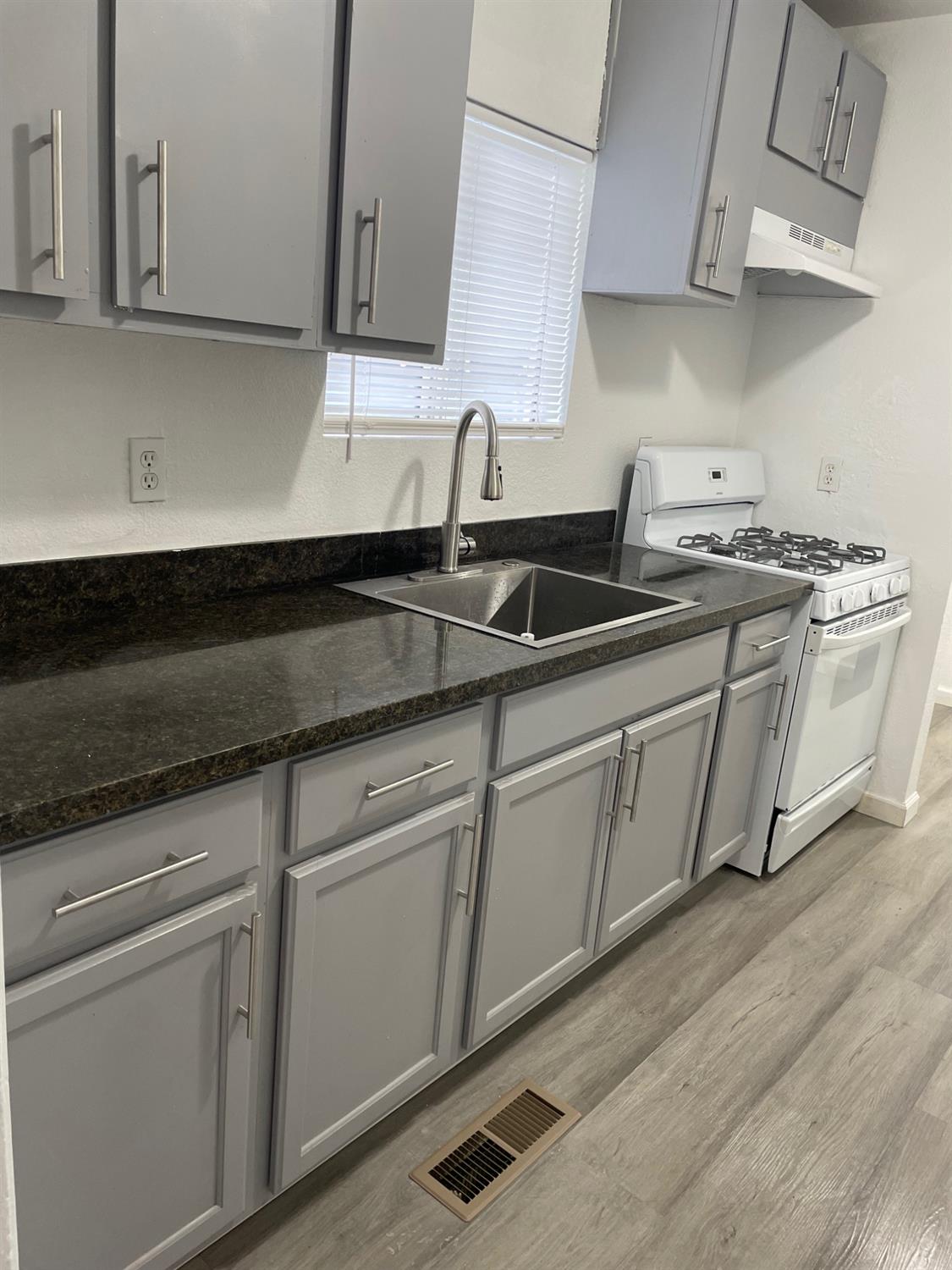 421 East Elm Street Lodi, CA 95240 - Photo 3 of 17 a kitchen with stainless steel appliances granite countertop a sink a stove and cabinets