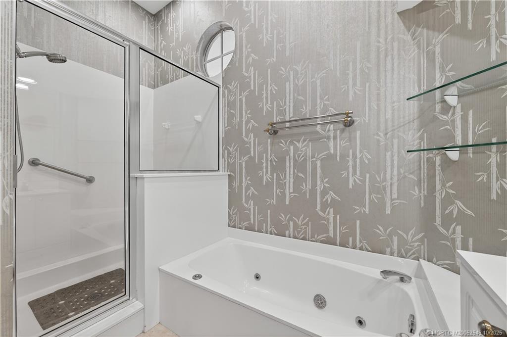 13009 Harbour Ridge Boulevard Palm City, FL 34990 - Photo 17 of 38 a bathroom with a bathtub and a shower