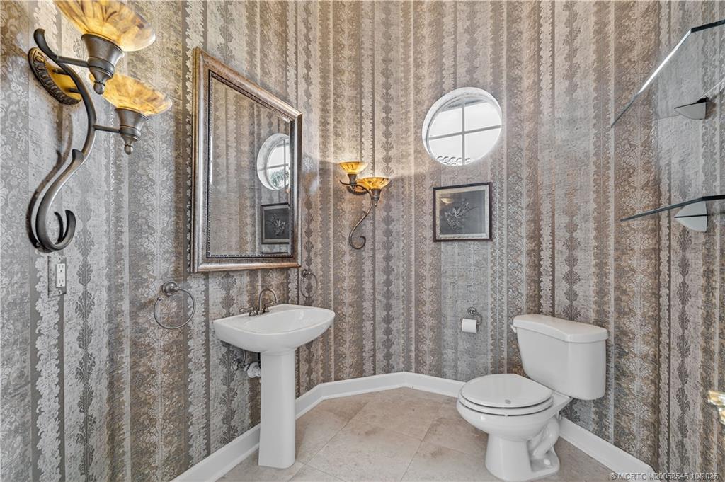 13009 Harbour Ridge Boulevard Palm City, FL 34990 - Photo 21 of 38 a bathroom with a toilet sink and mirror