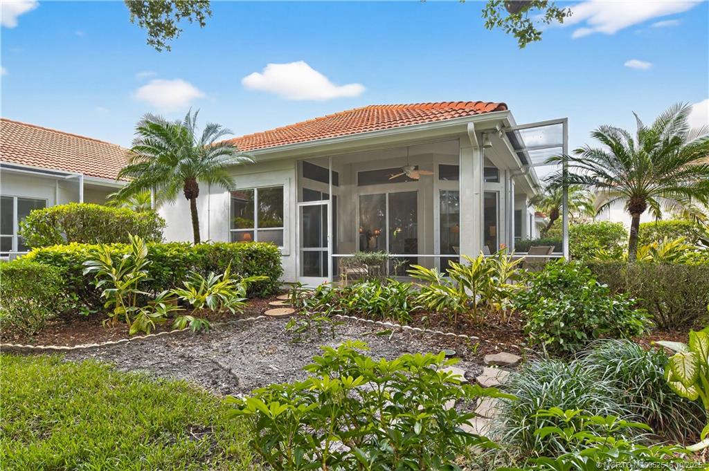 13009 Harbour Ridge Boulevard Palm City, FL 34990 - Photo 25 of 38 a front view of a house with a garden