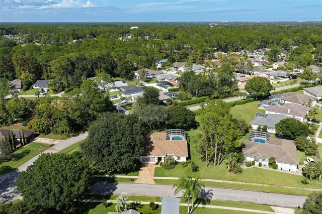 an aerial view of residential houses with outdoor space and trees