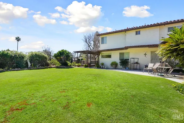 a view of a patio with table and chairs under an umbrella with wooden fence