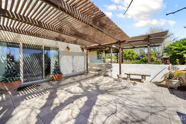 a view of a white house with a big yard and potted plants