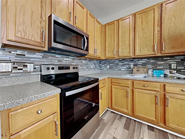 a kitchen with granite countertop a stove sink and microwave