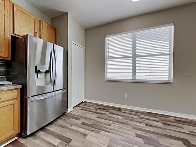 a view of a kitchen with a refrigerator and a window