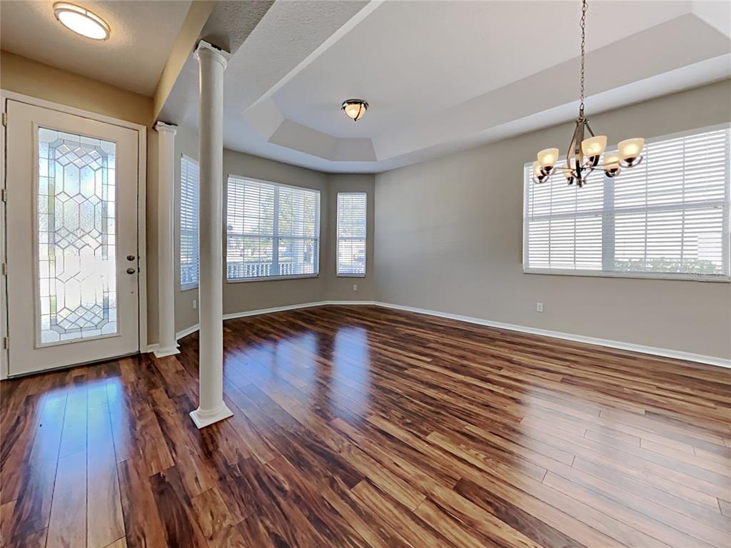 14136 Bradbury Road Orlando, FL 32828 - Photo 3 of 24 a view of an empty room with wooden floor and a window