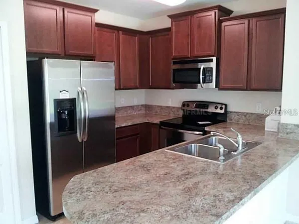 a kitchen with stainless steel appliances granite countertop a refrigerator stove a sink and dishwasher
