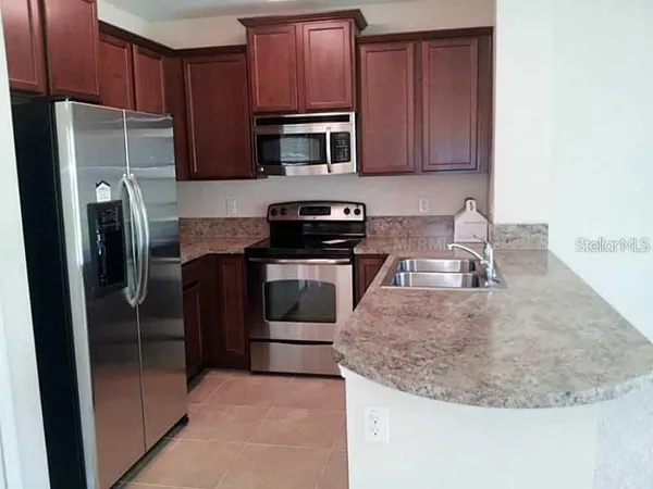 a kitchen with stainless steel appliances granite countertop a refrigerator stove and sink