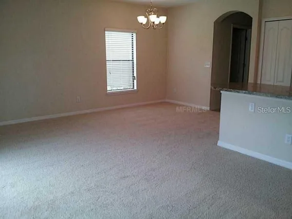 an empty room with chandelier fan