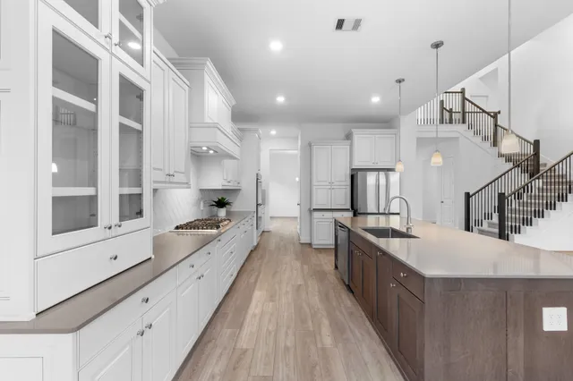 a large white kitchen with stainless steel appliances
