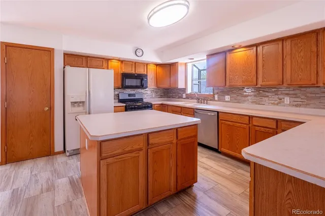 a kitchen with a stove a sink and a refrigerator