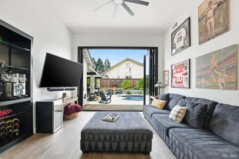 a living room with furniture a flat screen tv and a floor to ceiling window