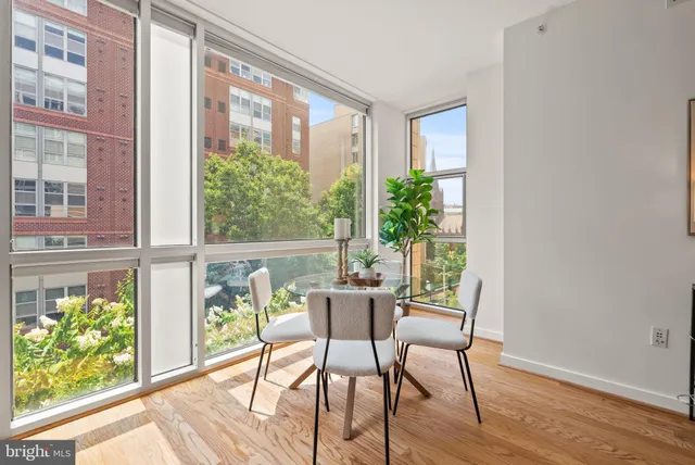 a dining room with wooden floor and windows